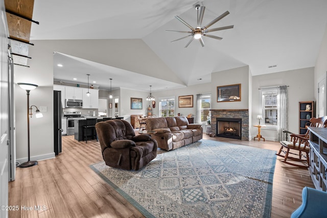 442 Crows Nest Ln, Sneads Ferry, NC 28460 - living area with a ceiling fan, light wood-type flooring, a stone fireplace, high vaulted ceiling, and baseboards