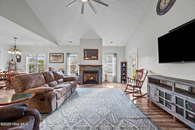 442 Crows Nest Ln, Sneads Ferry, NC 28460 - living room featuring lofted ceiling, ceiling fan, wood finished floors, a stone fireplace, and a chandelier
