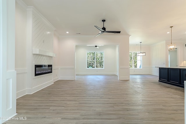 2967 Lake Pointe Dr SW, Supply, NC 28462 - unfurnished living room with a fireplace, a decorative wall, light wood finished floors, and ornamental molding