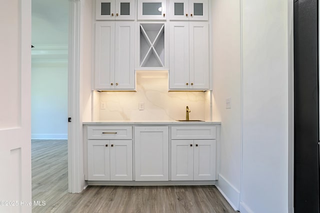 2967 Lake Pointe Dr SW, Supply, NC 28462 - bar with light wood-type flooring, decorative backsplash, baseboards, and a sink