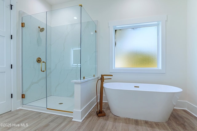 2967 Lake Pointe Dr SW, Supply, NC 28462 - bathroom featuring baseboards, a soaking tub, wood finished floors, and a marble finish shower