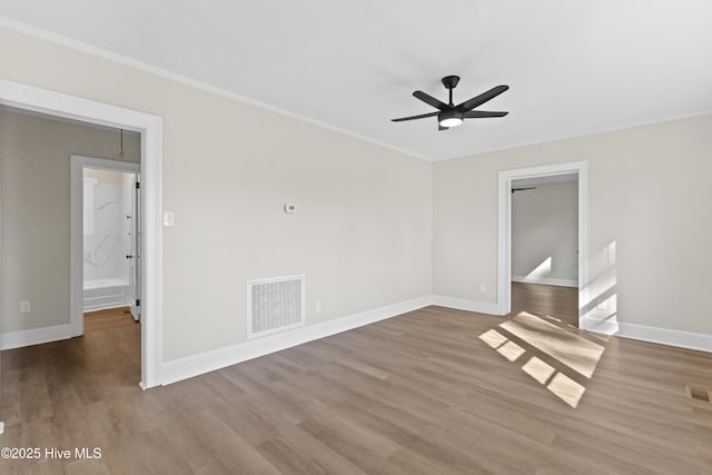 spare room with ceiling fan, crown molding, and visible vents