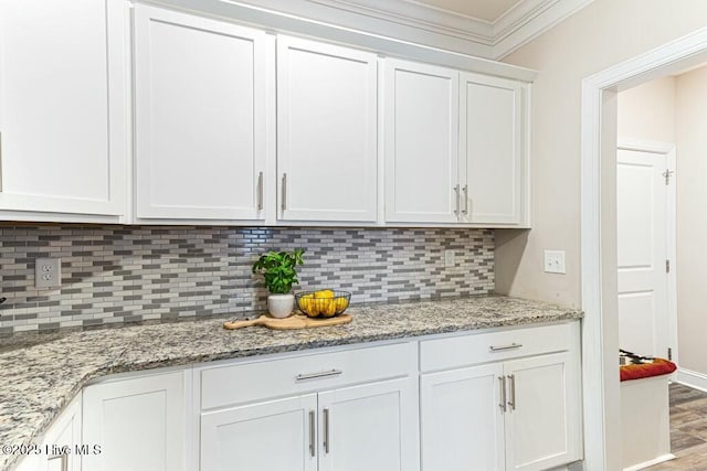 320 Thorne Rd, Pinehurst, NC 28374 - kitchen with white cabinets, ornamental molding, tasteful backsplash, wood finished floors, and light stone counters