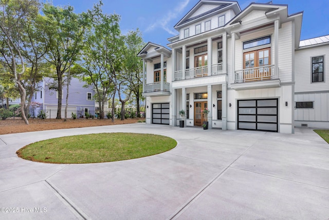 view of front facade with an attached garage, curved driveway, fence, and a balcony