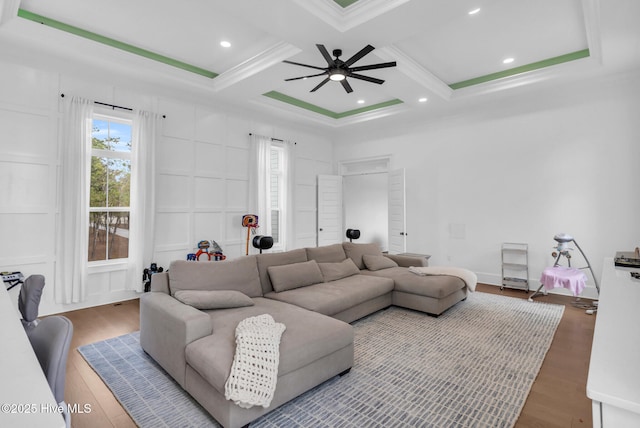 living area with ceiling fan, crown molding, beamed ceiling, wood finished floors, and coffered ceiling