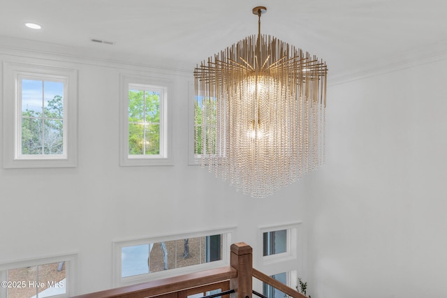 details featuring a chandelier, crown molding, and visible vents