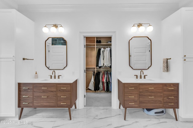 bathroom featuring two vanities, marble finish floor, and a sink