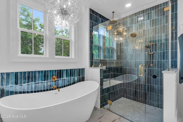 bathroom with a chandelier, a freestanding bath, marble finish floor, and a stall shower