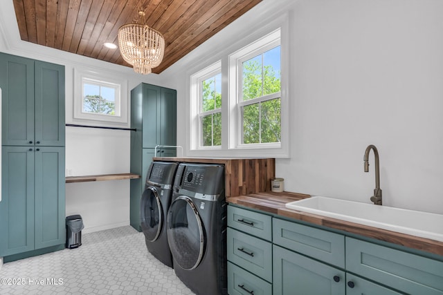 clothes washing area featuring a wealth of natural light, wooden ceiling, a sink, washer and dryer, and cabinet space