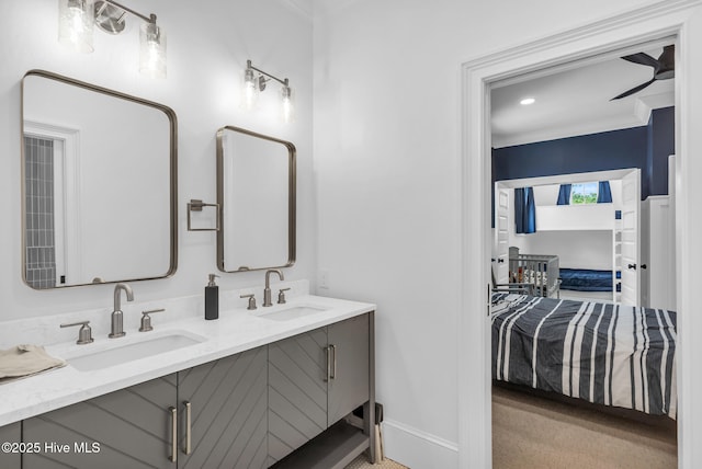 full bathroom with a sink, baseboards, double vanity, and crown molding