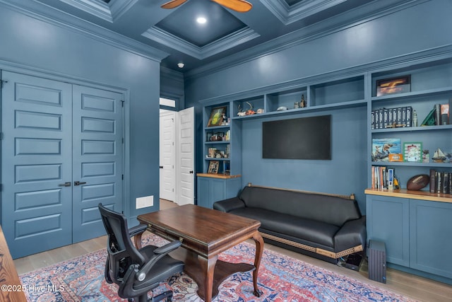 home office with visible vents, ornamental molding, light wood-type flooring, a ceiling fan, and coffered ceiling
