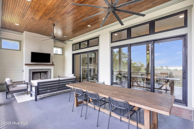 view of patio with an outdoor living space with a fireplace, ceiling fan, and outdoor dining area