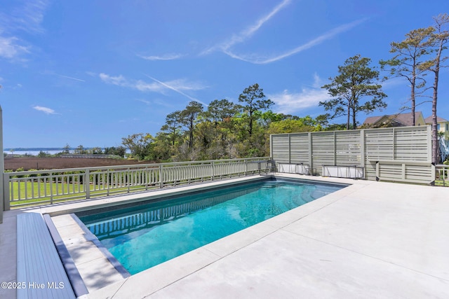view of swimming pool featuring a patio area, fence, and a fenced in pool