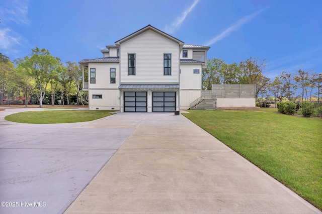 view of side of home featuring driveway, an attached garage, stairs, a standing seam roof, and metal roof