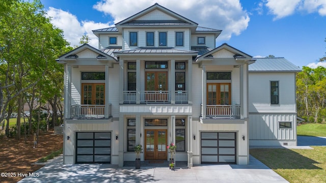 view of front of house with french doors, a standing seam roof, metal roof, and a garage