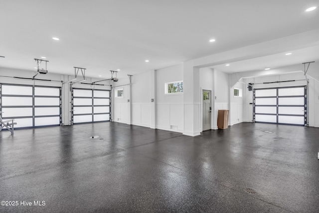 garage featuring a garage door opener, wainscoting, and recessed lighting