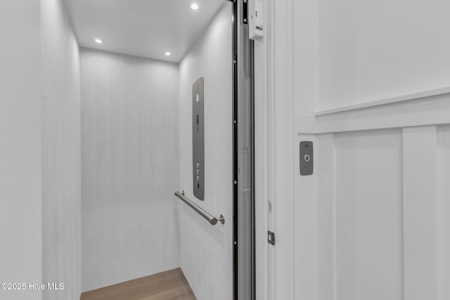 interior details with elevator, recessed lighting, and wood finished floors