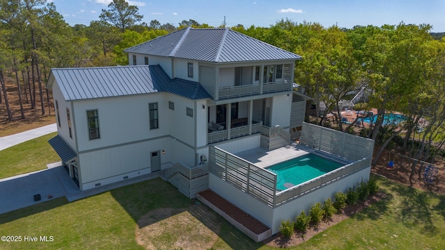 rear view of house featuring crawl space, a lawn, metal roof, and a standing seam roof