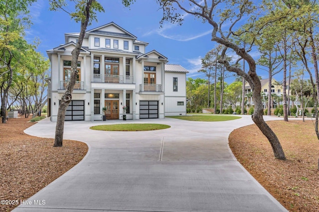 view of front of house featuring a balcony, french doors, an attached garage, and curved driveway