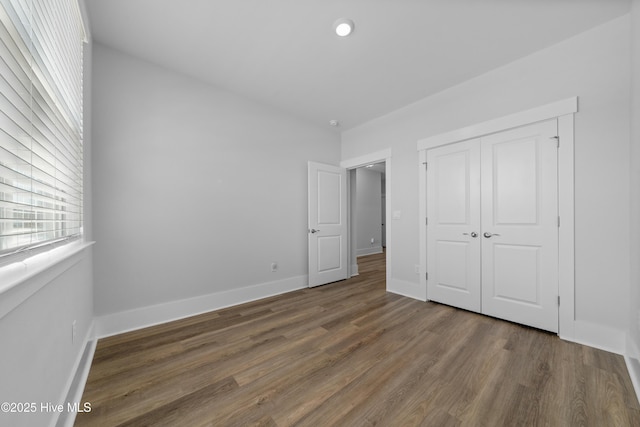 7801 Harrier Cir, Leland, NC 28451 - unfurnished bedroom with a closet, baseboards, and wood finished floors