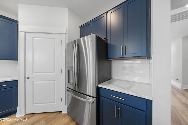 7801 Harrier Cir, Leland, NC 28451 - kitchen featuring tasteful backsplash, light wood-type flooring, blue cabinets, and stainless steel refrigerator with ice dispenser