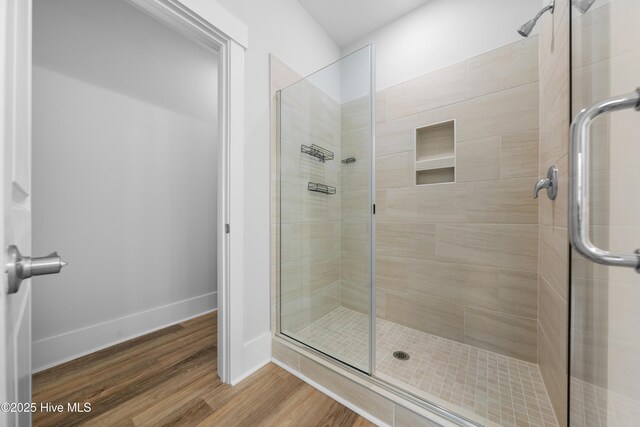7801 Harrier Cir, Leland, NC 28451 - bathroom with baseboards, a stall shower, and wood finished floors