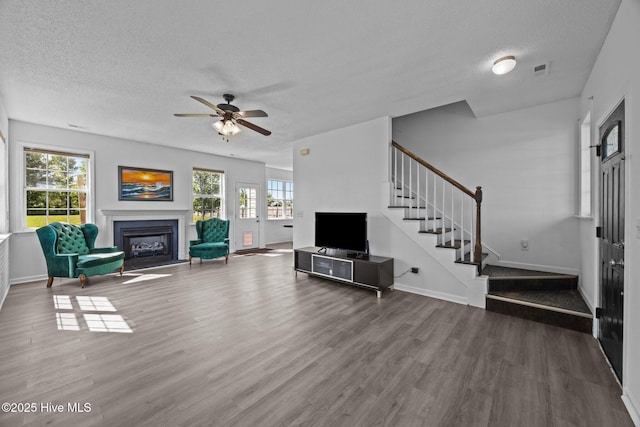 106 Hardin Dr, Maysville, NC 28555 - living area with a textured ceiling, wood finished floors, a glass covered fireplace, stairs, and ceiling fan