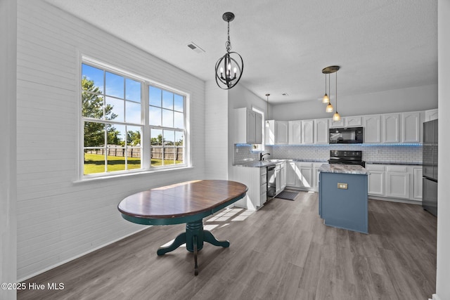 106 Hardin Dr, Maysville, NC 28555 - kitchen featuring black appliances, plenty of natural light, a kitchen island, white cabinets, and a textured ceiling