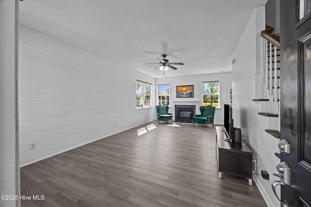 106 Hardin Dr, Maysville, NC 28555 - living area featuring a textured ceiling, a ceiling fan, a glass covered fireplace, wood finished floors, and baseboards