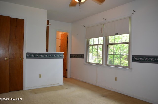 empty room featuring carpet flooring and a ceiling fan