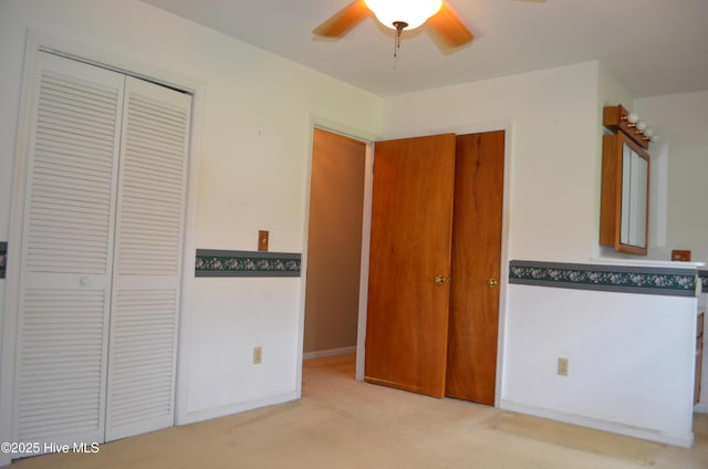 unfurnished bedroom featuring a closet, a ceiling fan, and carpet