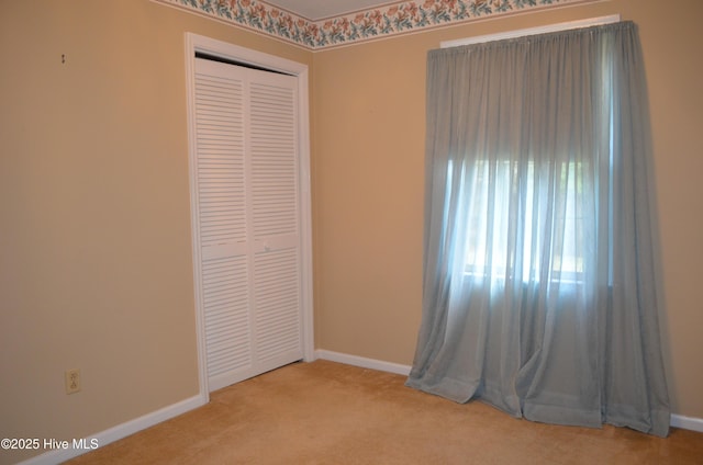 carpeted empty room with baseboards