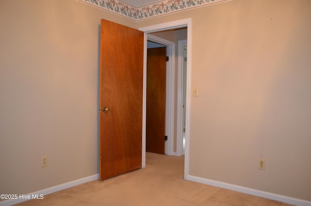 empty room featuring carpet floors and baseboards