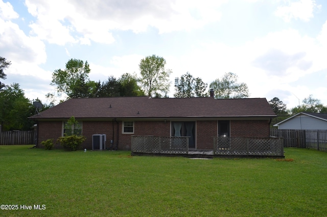 back of house featuring a yard, brick siding, central AC, and fence