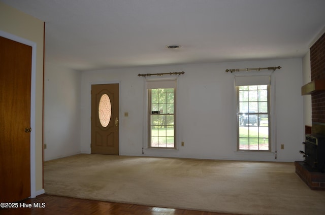interior space featuring visible vents, a wood stove, and plenty of natural light