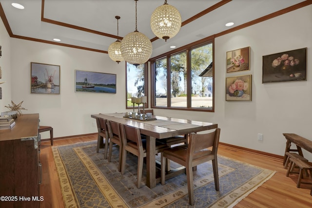 1409 Landfall Dr, Wilmington, NC 28405 - dining room with a chandelier, crown molding, a raised ceiling, baseboards, and wood finished floors