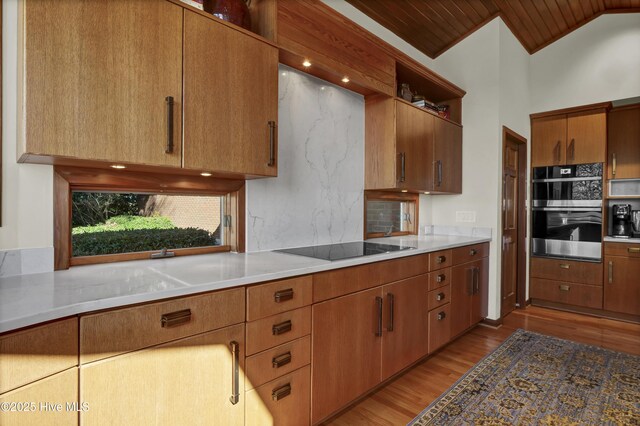 1409 Landfall Dr, Wilmington, NC 28405 - kitchen with black electric stovetop, backsplash, light wood-style floors, stainless steel double oven, and open shelves