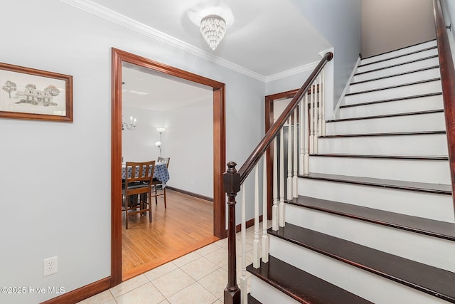 stairs with a chandelier, ornamental molding, baseboards, and tile patterned flooring