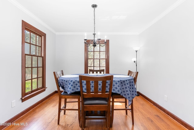 dining area with light wood-type flooring, an inviting chandelier, and a wealth of natural light