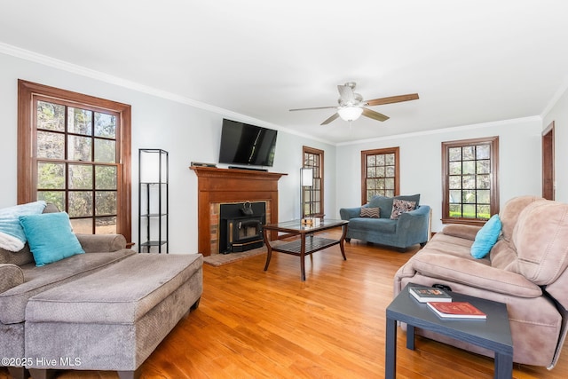 living room with light wood-style floors, ceiling fan, and crown molding