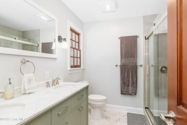 bathroom with double vanity, a stall shower, toilet, marble finish floor, and a sink