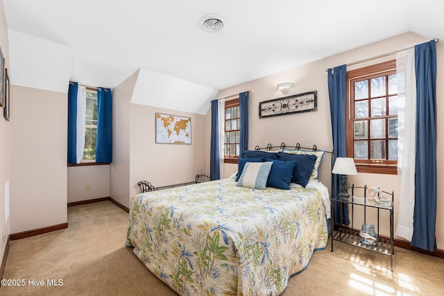 bedroom with visible vents, carpet floors, baseboards, and vaulted ceiling