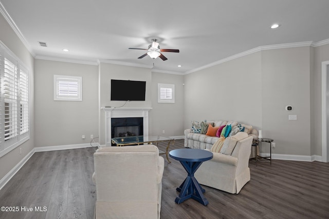 living area featuring a fireplace, wood finished floors, a healthy amount of sunlight, and a ceiling fan