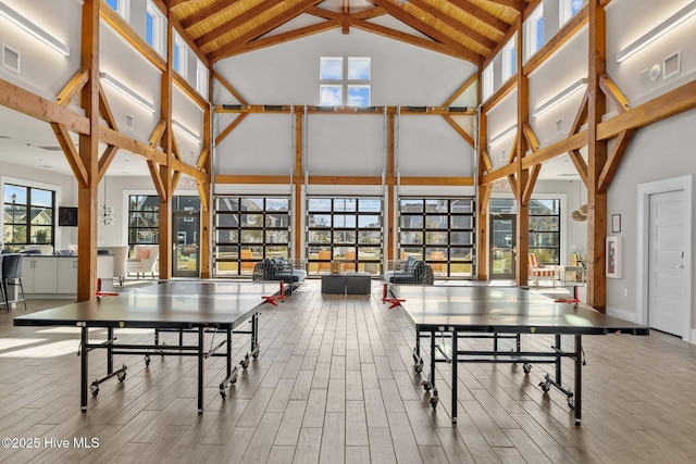 recreation room with high vaulted ceiling, beamed ceiling, wood finished floors, and visible vents