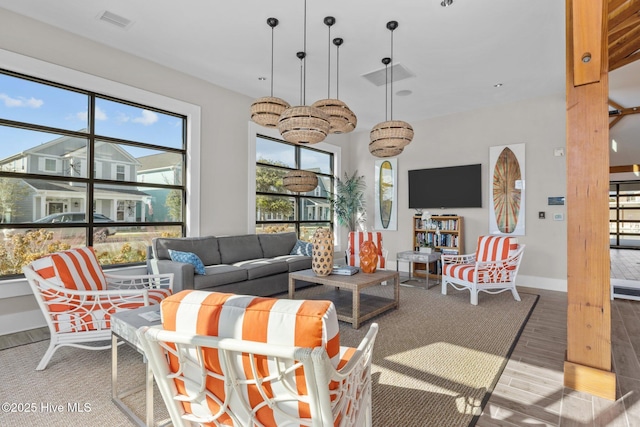 living area featuring wood finished floors, visible vents, and baseboards