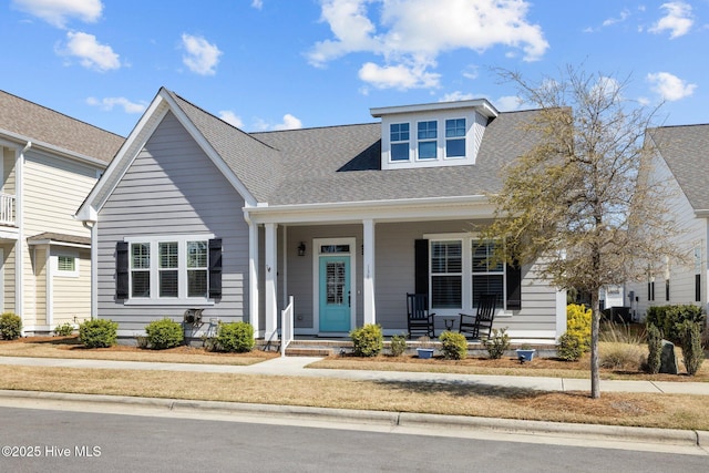 view of front of property featuring a shingled roof and covered porch