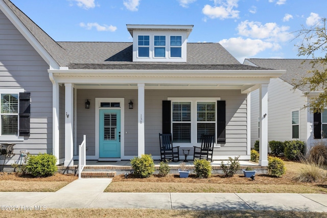entrance to property with roof with shingles and a porch
