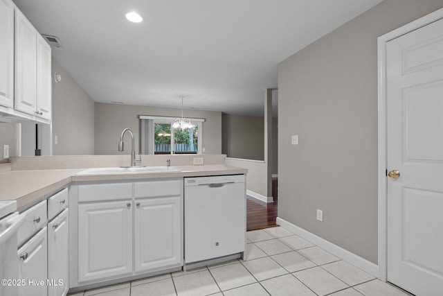 424 Commerce Ave Unit B, Morehead City, NC 28557 - kitchen featuring light countertops, white dishwasher, a sink, visible vents, and a peninsula