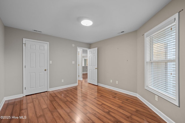 424 Commerce Ave Unit B, Morehead City, NC 28557 - unfurnished bedroom with wood finished floors, visible vents, and baseboards