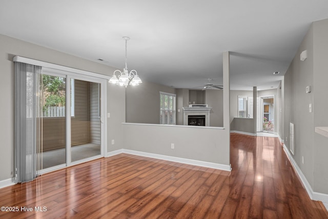 424 Commerce Ave Unit B, Morehead City, NC 28557 - unfurnished living room featuring a fireplace, wood finished floors, baseboards, and ceiling fan with notable chandelier